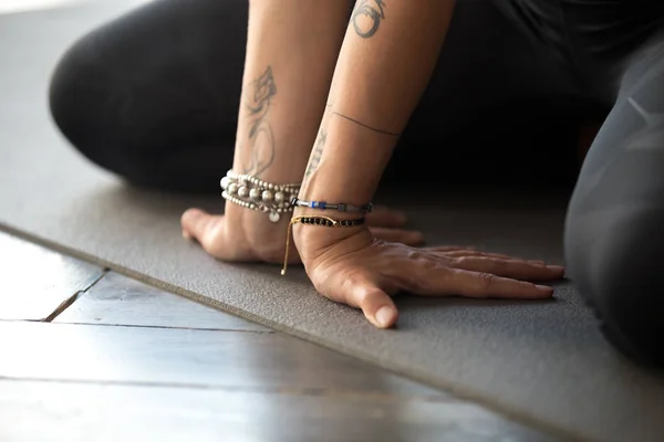 Sporty yogi woman practicing yoga, doing wrist and fingers exerc