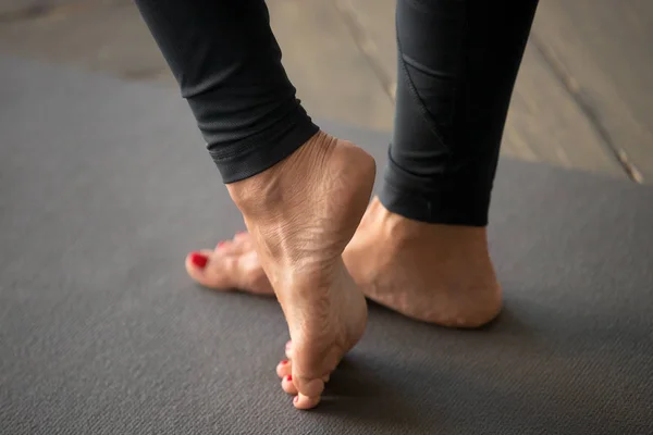 Mujer deportiva activa practicando yoga, haciendo ejercicios de pies —  Fotos de Stock