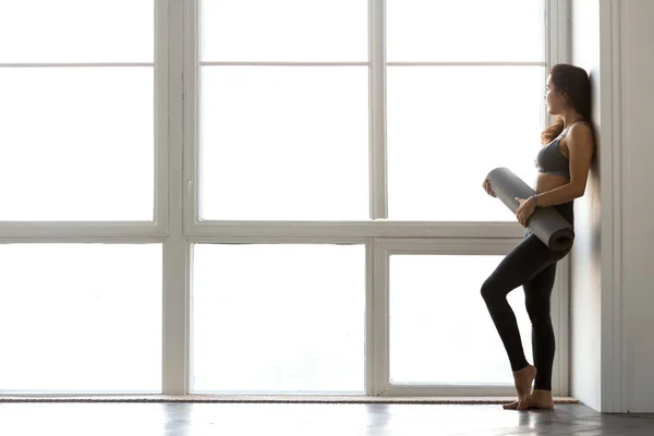 Delgado deportivo atractiva mujer de pie celebración de yoga o fitness ma — Foto de Stock