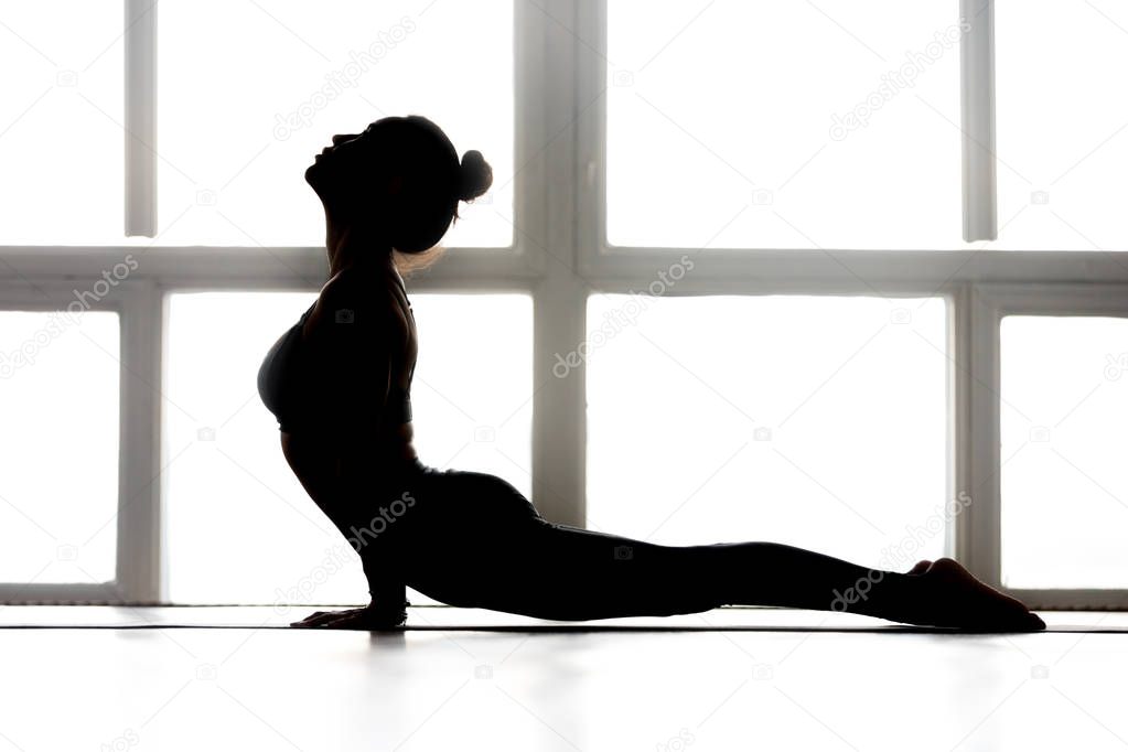 Young sporty yogi woman practicing yoga, doing upward facing dog