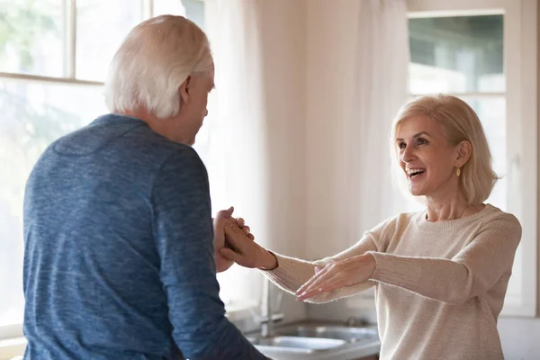 Старая счастливая пара танцует вместе на кухне — стоковое фото
