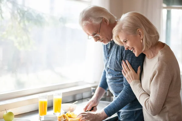 Marido mayor cocina desayuno saludable para la esposa feliz en casa — Foto de Stock