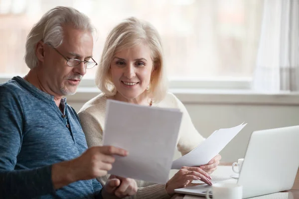 Feliz pareja mayor sosteniendo la lectura de buenas noticias en el documento — Foto de Stock