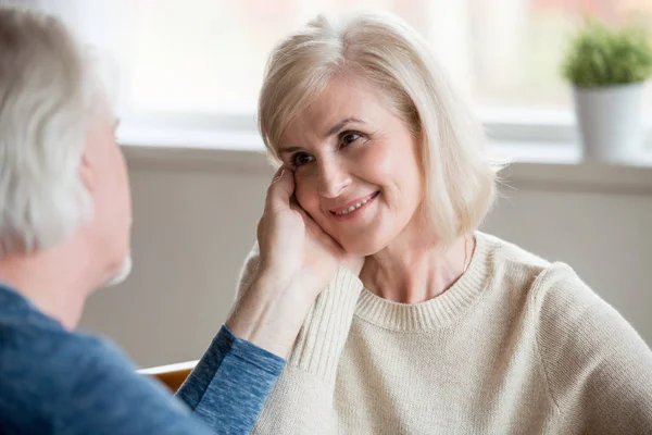 Fürsorgliche Senior Ehemann berührt schönes Gesicht des lächelnden alten wi — Stockfoto