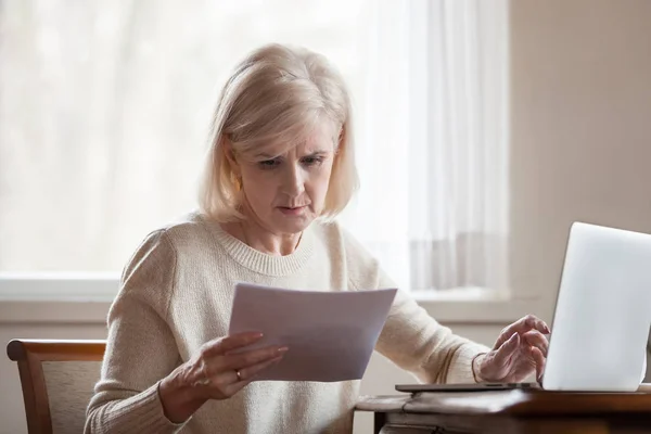 Frau mittleren Alters mit Haushaltsrechnung schwer frustriert — Stockfoto