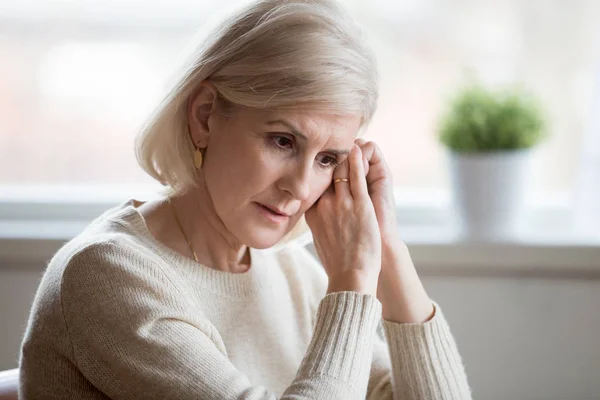 Задумчивая грустная женщина средних лет чувствует себя синей, думая о тревоге. — стоковое фото
