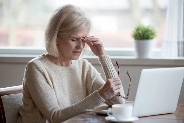 Müde reife Frau nimmt Brille ab und leidet an Augenkrankheit — Stockfoto