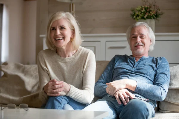 Ευτυχισμένο ζευγάρι γέλιο βλέποντας τηλεόραση μαζί στο σαλόνι — Φωτογραφία Αρχείου