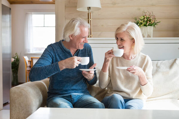 Feliz casal sênior falando se divertindo desfrutando de chá em casa — Fotografia de Stock