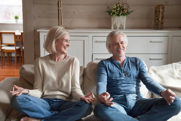 Pareja mayor divirtiéndose riendo haciendo yoga juntos en casa — Foto de Stock