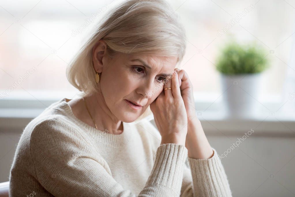 Thoughtful sad middle aged woman feeling blue thinking of anxiet