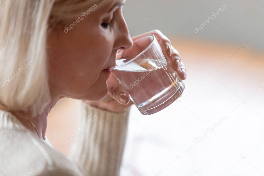 Dehydrated healthy senior woman feeling thirsty drinking water, 