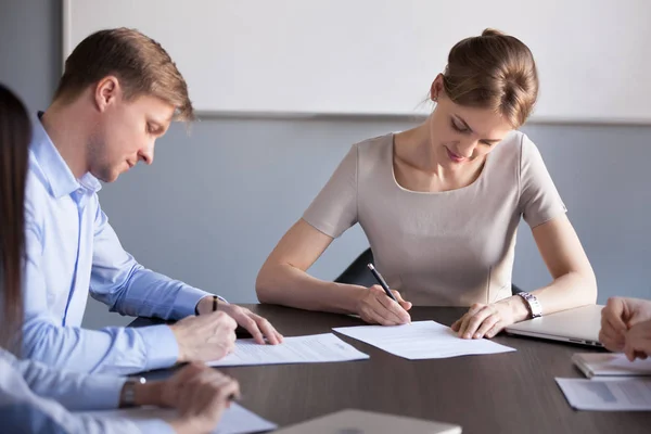 Socios comerciales masculinos y femeninos firmando contratos acordando — Foto de Stock