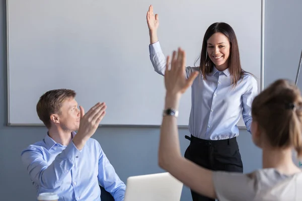 Business people and female team leader raising hands expressing — Stock Photo, Image