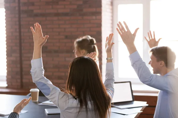 Vista trasera a los empleados felices levantando las manos emocionados por el éxito —  Fotos de Stock