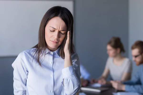 Stressed frustrated businesswoman touching temple feeling strong — Stock Photo, Image