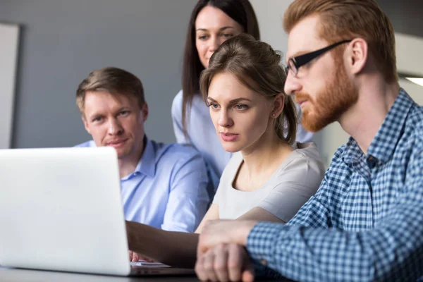 Serious team leader explaining online data on laptop to colleagu — Stock Photo, Image