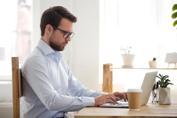 Forretningsmann som skriver på datamaskin som arbeider i kontorlokalet – stockfoto