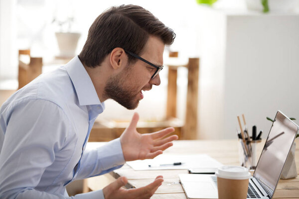 Irritated business person sitting working in office 