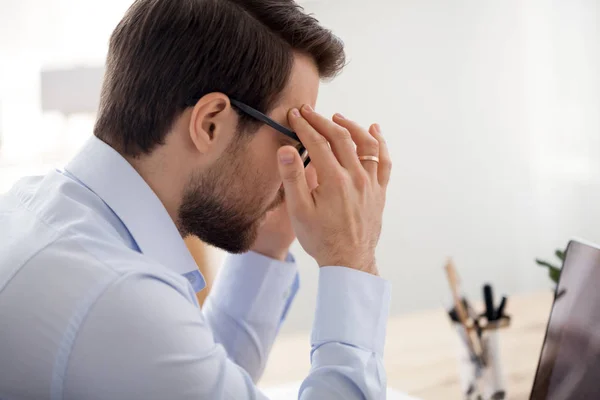 Müder Geschäftsmann mit Kopfschmerzen im Büro — Stockfoto