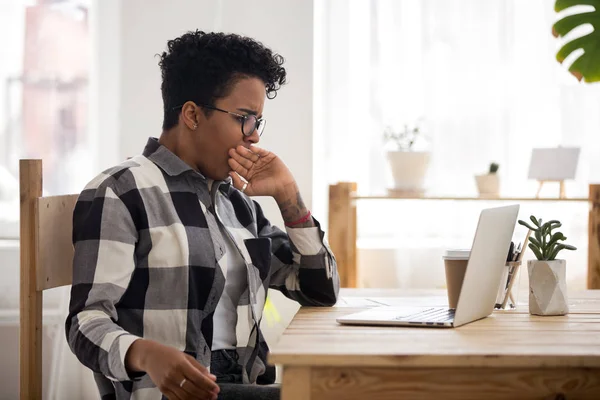 Femme noire ennuyeuse assise au bureau — Photo