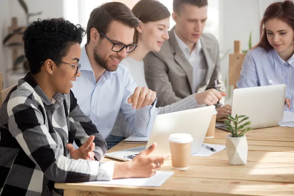 Jóvenes empleados sentados en el escritorio en la oficina en la reunión — Foto de Stock