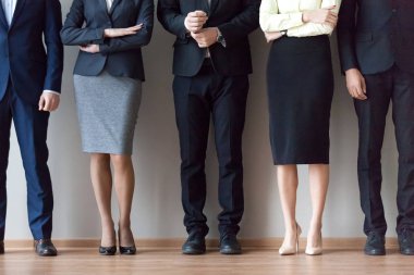 Çeşitli iş takım ayakta sıra ofis duvarının yakınında