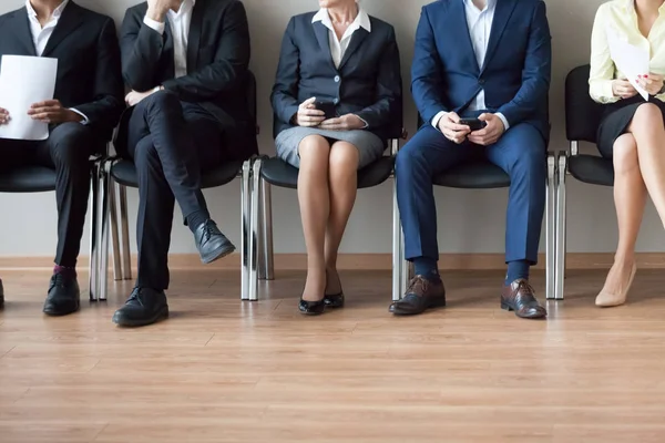 Legs of diverse work candidates waiting in turn for interview — Stock Photo, Image