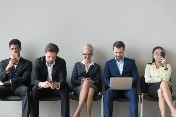 Multiethnic work candidate using gadgets before interview — Stock Photo, Image