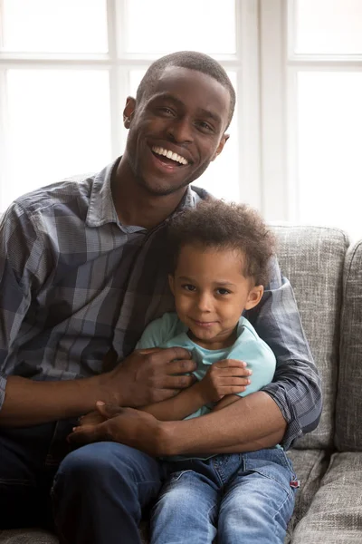 Père aimant avec petit fils assis regardant la caméra à l'intérieur — Photo