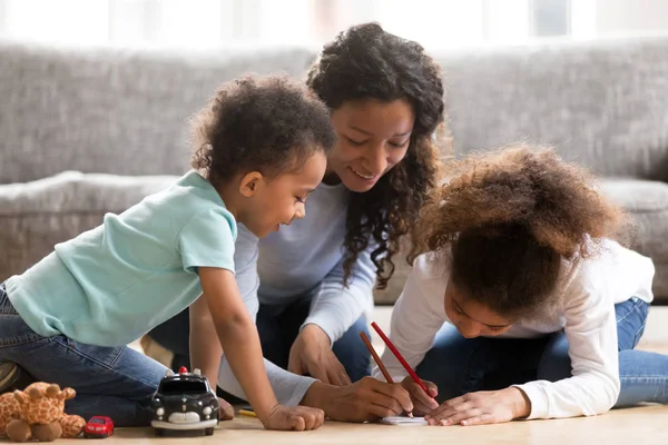 Zwarte moeder tekenen met kinderen thuis — Stockfoto