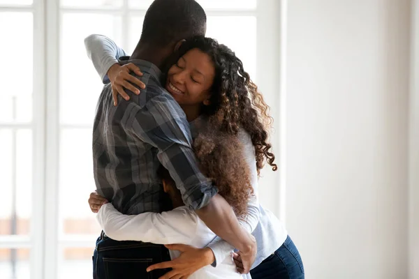 Happy black family hugging in room at home — Stock Photo, Image