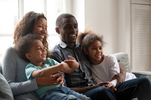 Black happy family together sitting on couch at home