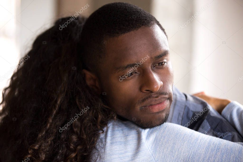 Black African woman embracing sad frustrated man