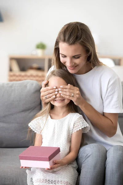 Glückliche Mutter schließt Tochter Augen präsentiert Geburtstagsgeschenk — Stockfoto