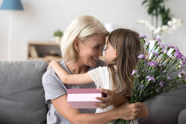 Счастливая бабушка благодарит милую внучку за цветы и Ги — стоковое фото