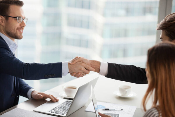 Young businessman handshaking business partner after successful negotiations. Deal with good result, start of work with business partner, conclusion of an agreement, good relationships, human