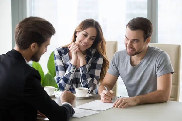 Pareja joven firma contrato con agente inmobiliario, banquero —  Fotos de Stock