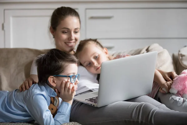 Alleinerziehende Mutter und zwei Kinder schauen Film auf Laptop — Stockfoto