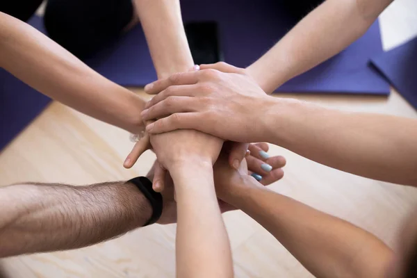 Close up sporty people stacking hands at training studio — Stock Photo, Image
