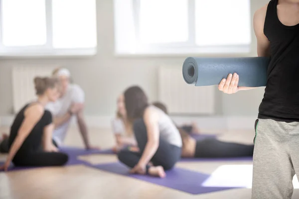 Oigenkännlig mannen hålla yoga matta grupp sportiga människor på backg — Stockfoto