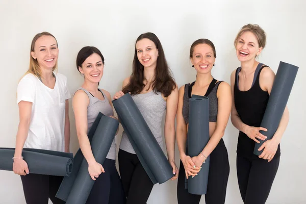 Groep sportieve gelukkig vrouwen houden van yoga matten permanent binnenshuis — Stockfoto