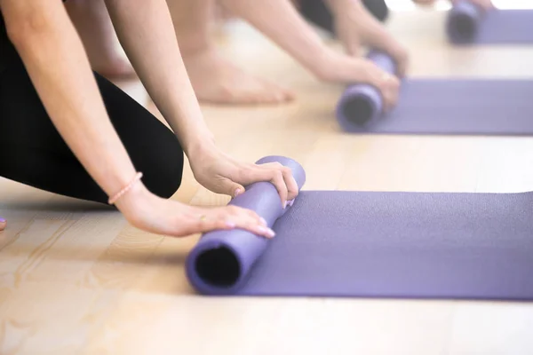 Close up people hands folding yoga mats — Stock Photo, Image