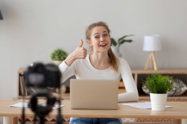 Happy woman blogger recording video showing thumbs up clipart