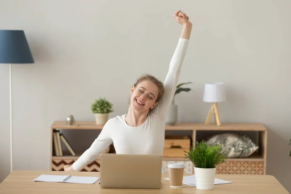 Nöjd tjej sitter vid skrivbord avkopplande i office — Stockfoto