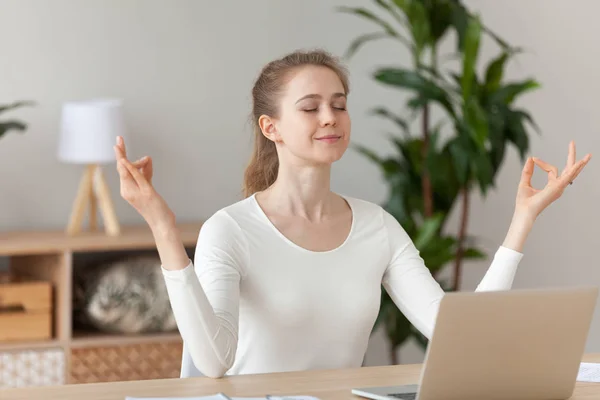 Woman meditating doing yoga sitting at workplace — Stock Photo, Image