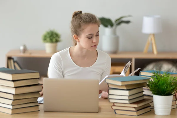 Ung koncentrerad kvinna studerar sitter vid skrivbordet — Stockfoto