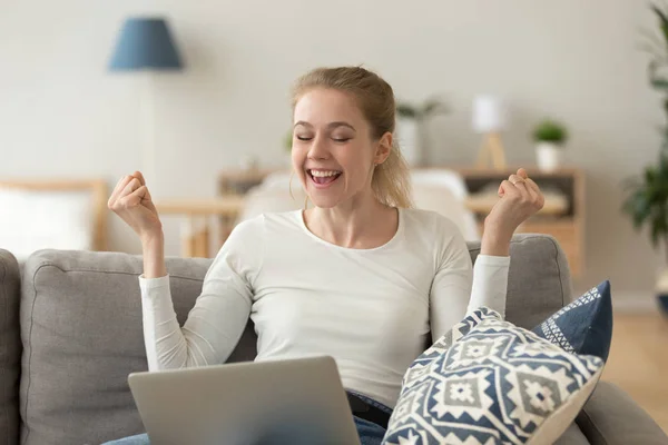 Happy laughing woman sitting on couch with laptop — Stock Photo, Image