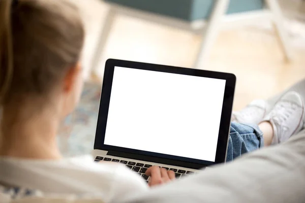 Girl using laptop sitting on couch at home — Stock Photo, Image