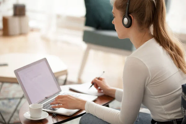 Woman wearing headset using laptop working or studying — Stock Photo, Image